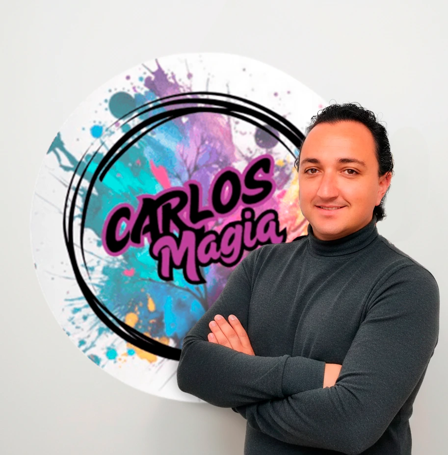 Carlos posando en una pared con su logo